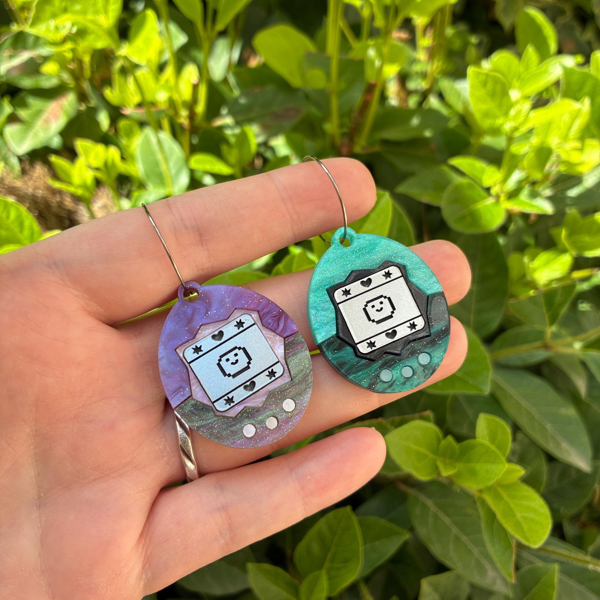Pendientes fanart de Tamagotchi. Diseñados, cortados, montados y pintados a mano en metacrilato. Muy ligeros.
