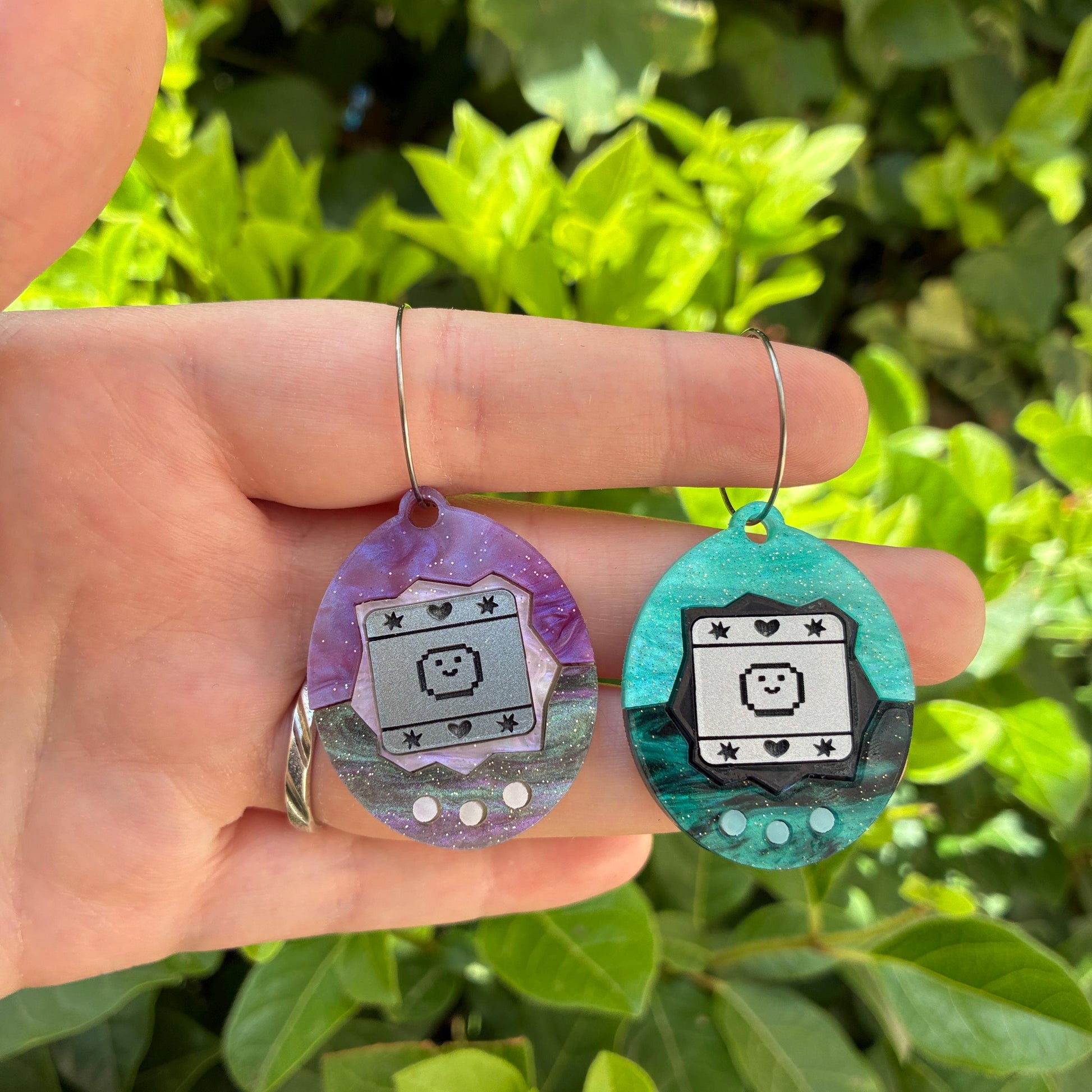 Pendientes fanart de Tamagotchi. Diseñados, cortados, montados y pintados a mano en metacrilato. Muy ligeros.