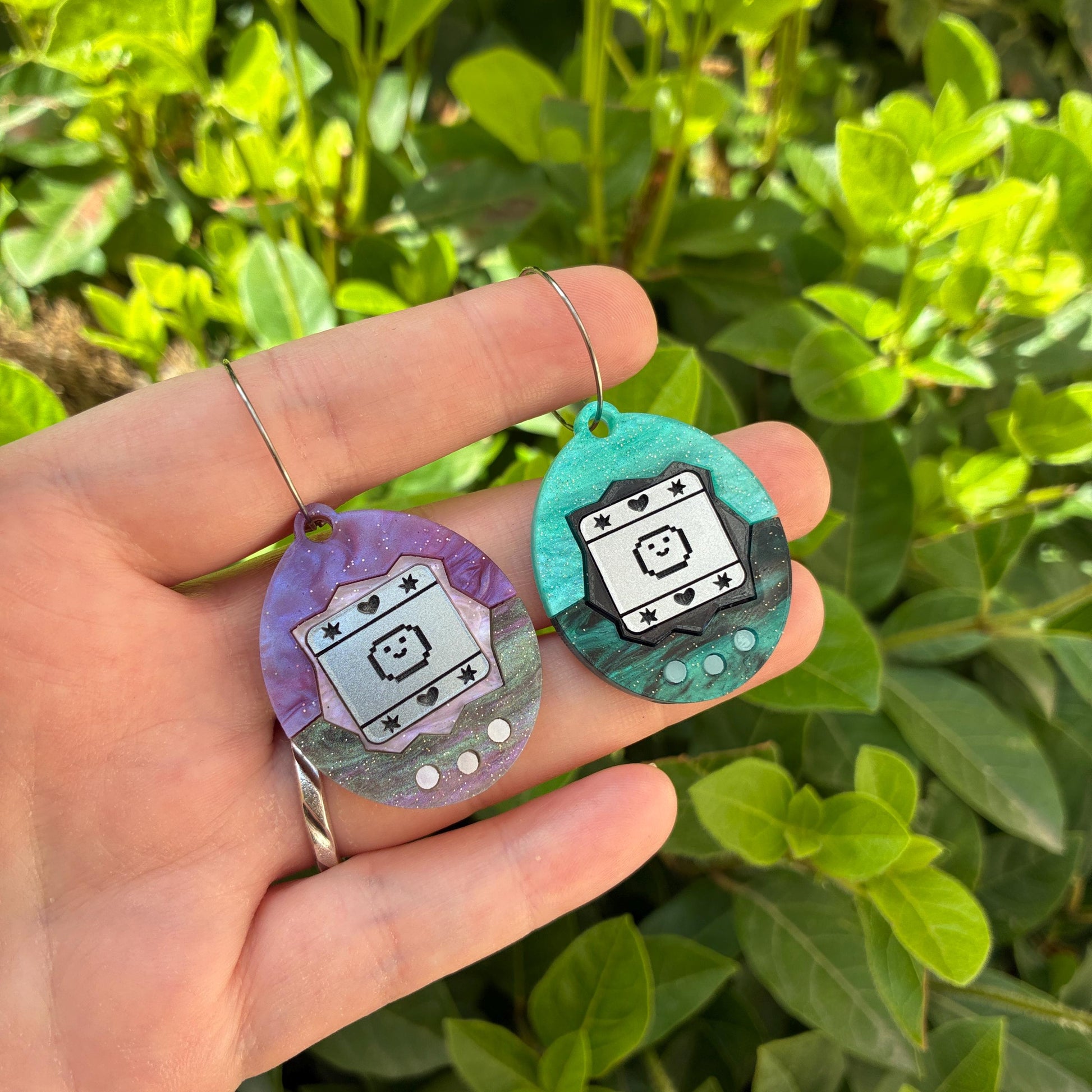 Pendientes fanart de Tamagotchi. Diseñados, cortados, montados y pintados a mano en metacrilato. Muy ligeros.