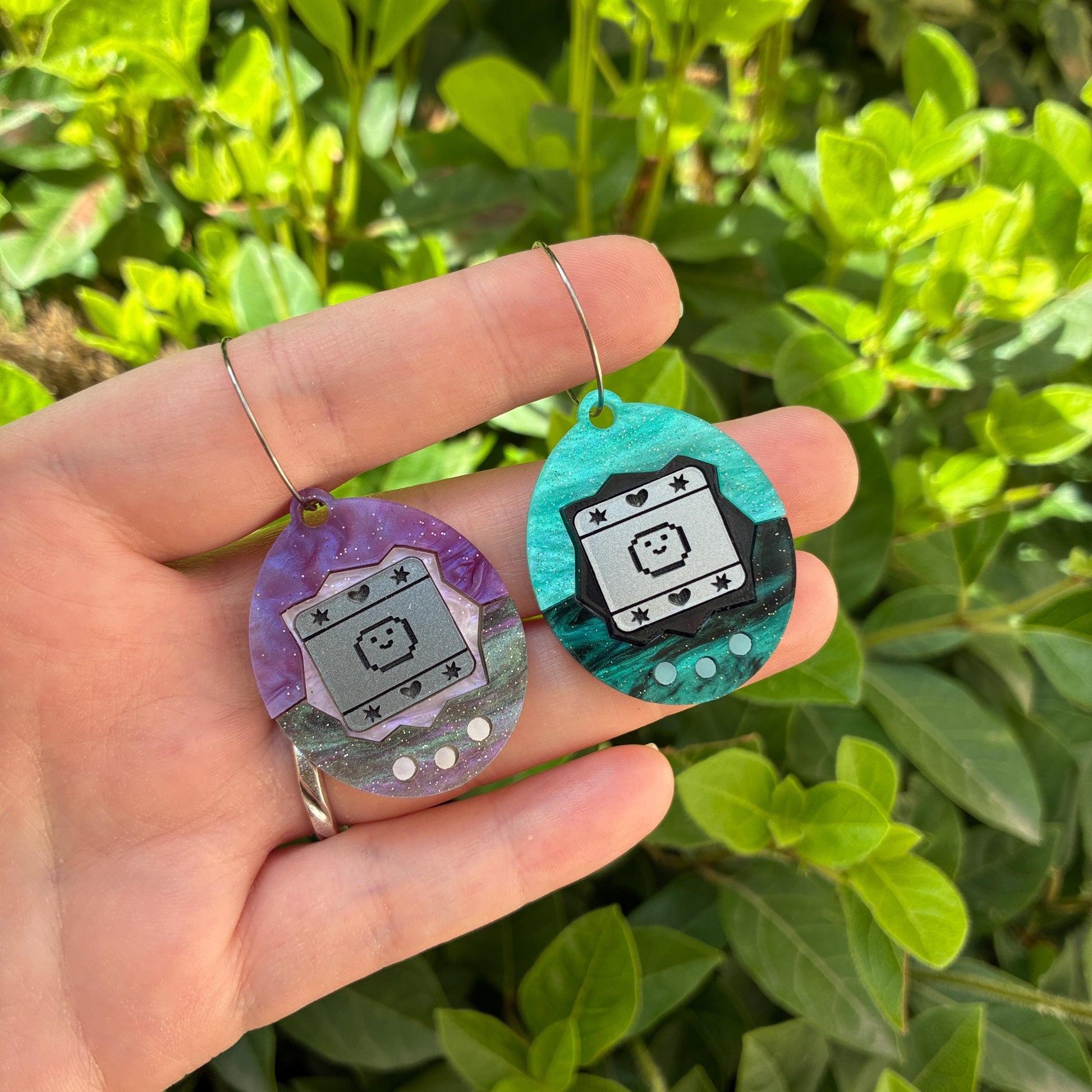 Pendientes fanart de Tamagotchi. Diseñados, cortados, montados y pintados a mano en metacrilato. Muy ligeros.